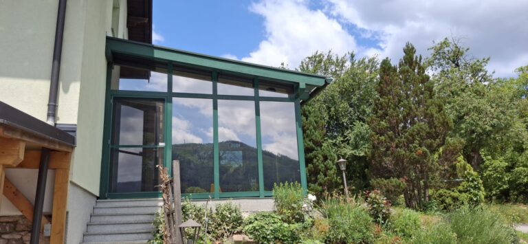 Kleines Glashaus mit grünen Rändern.