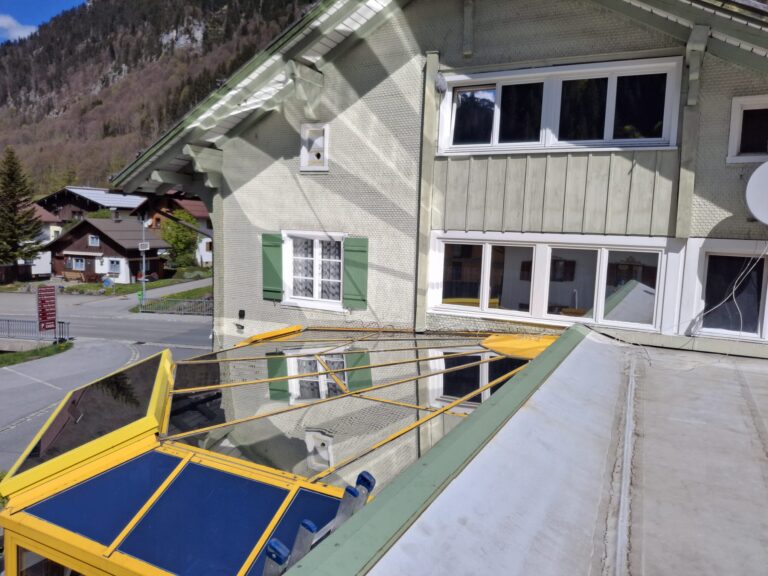 Verglaste gelbe Veranda eines Hauses.